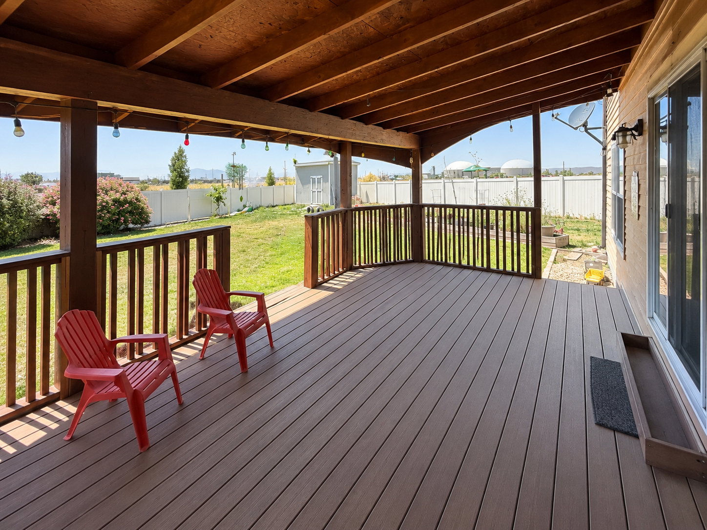 Covered outdoor deck featuring composite decking and wood railing