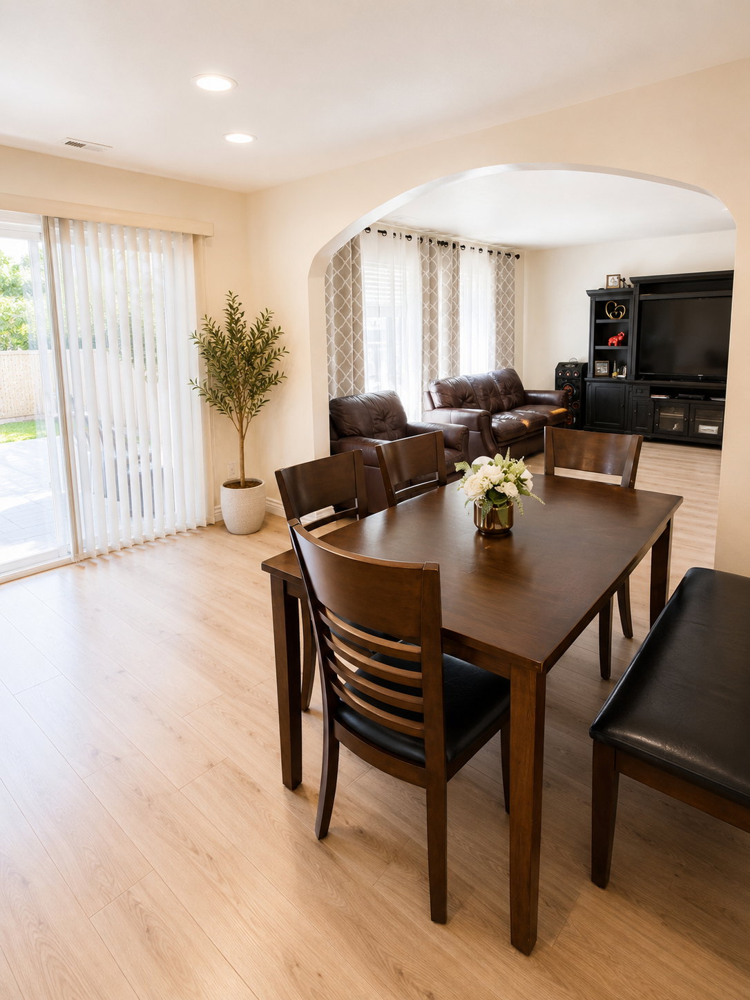 Dining area with light wood-finish flooring, recessed lighting, and sliding glass doors