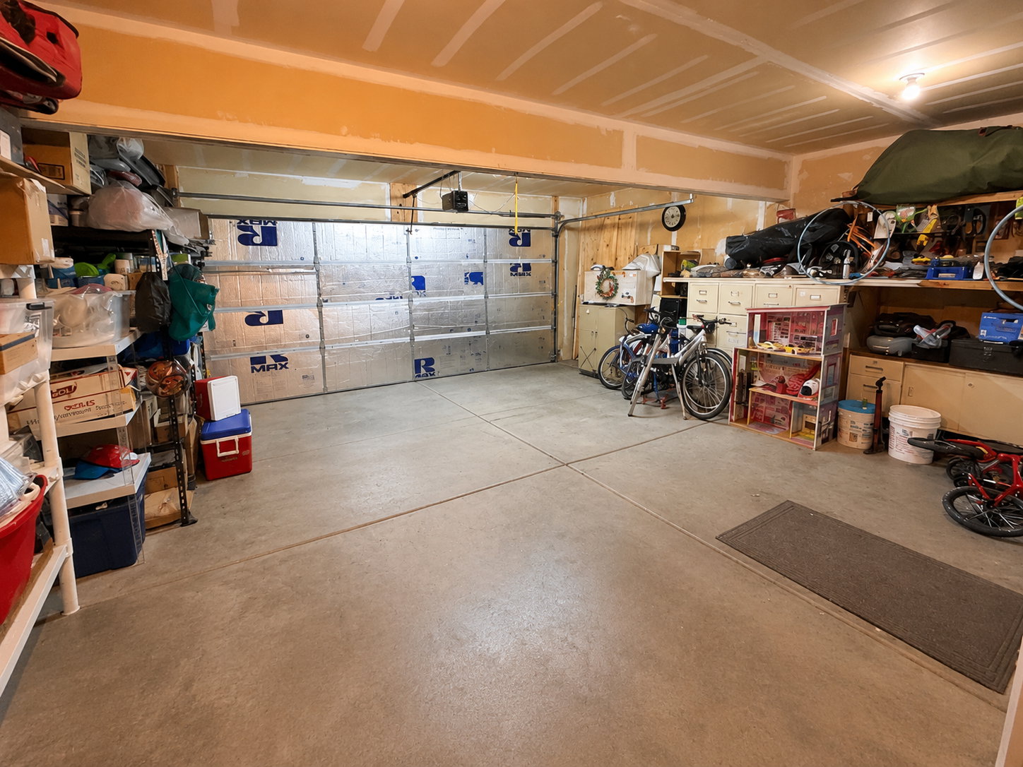 Spacious garage with exposed rafter ceiling and a single overhead door
