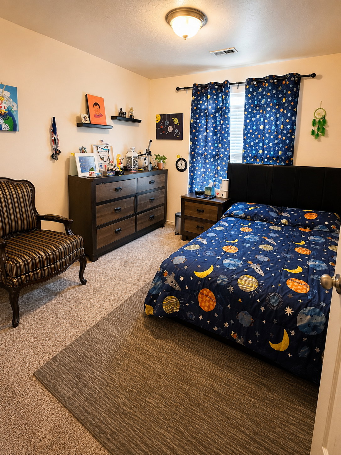 Carpeted bedroom featuring a window with blinds, a ceiling-mounted light fixture, and a solid door with a round knob