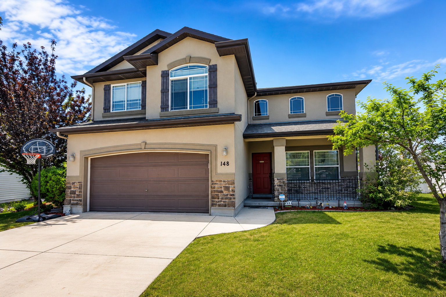 Two-story stucco and stone-clad residence with an attached two-car garage