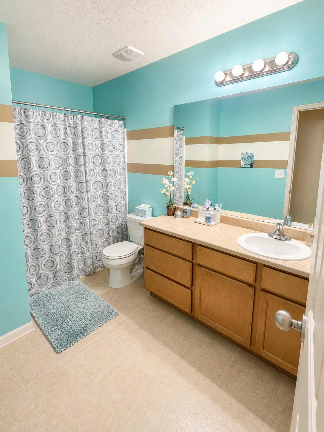 Bathroom featuring a light wood-finish vanity with ample storage