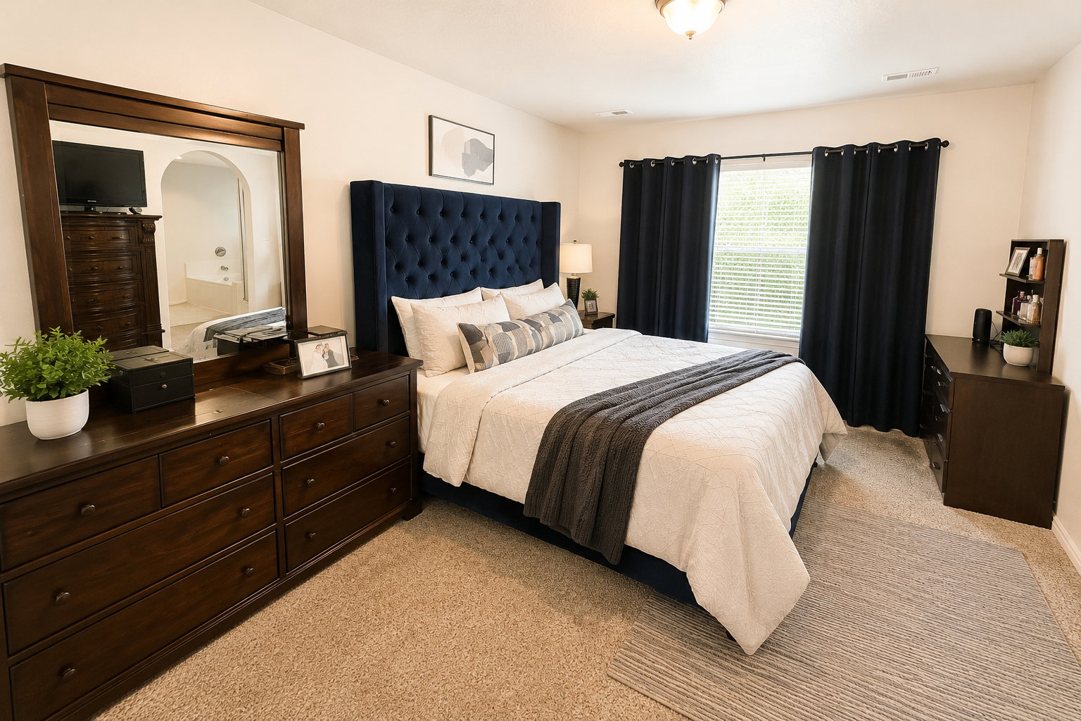 Carpeted bedroom featuring a window with blinds, a ceiling-mounted light fixture, and neutral wall paint
