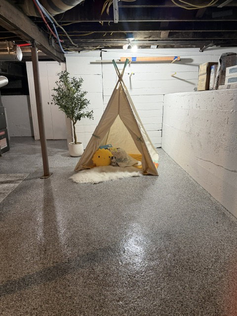 Finished concrete flooring with a speckled finish and exposed overhead joists