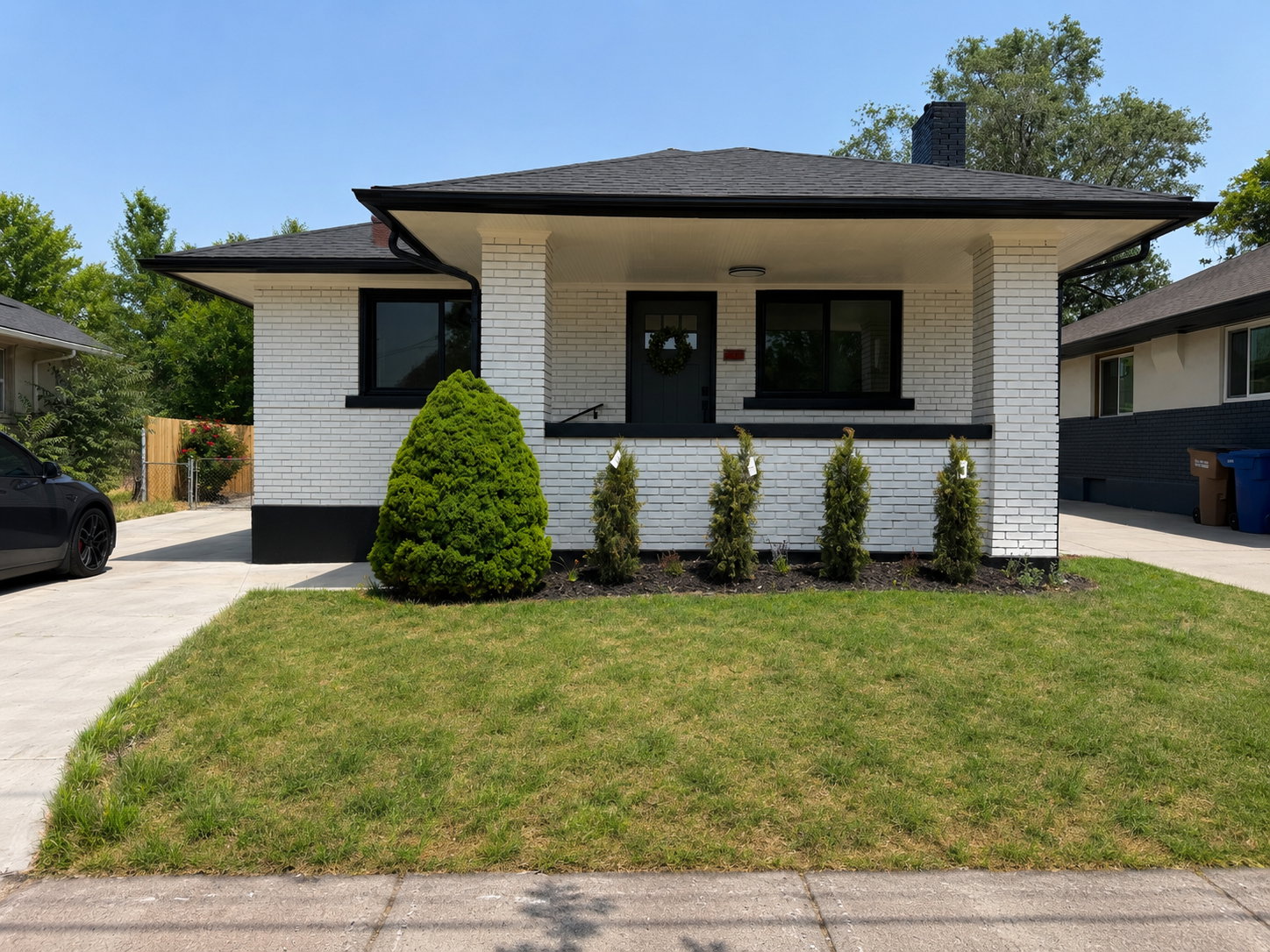 White brick exterior with black trim accents and a dark roofline