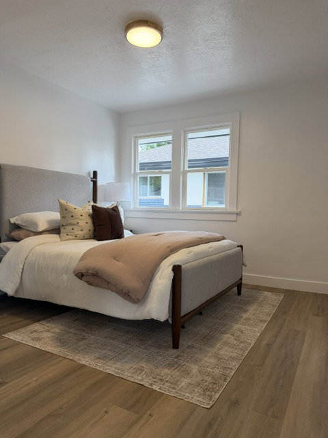 Bright room with wood-finish flooring, white trim, and a modern ceiling light fixture