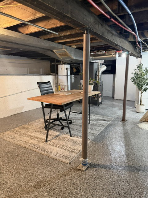 Utility space featuring exposed ceiling joists, concrete flooring, and visible ductwork