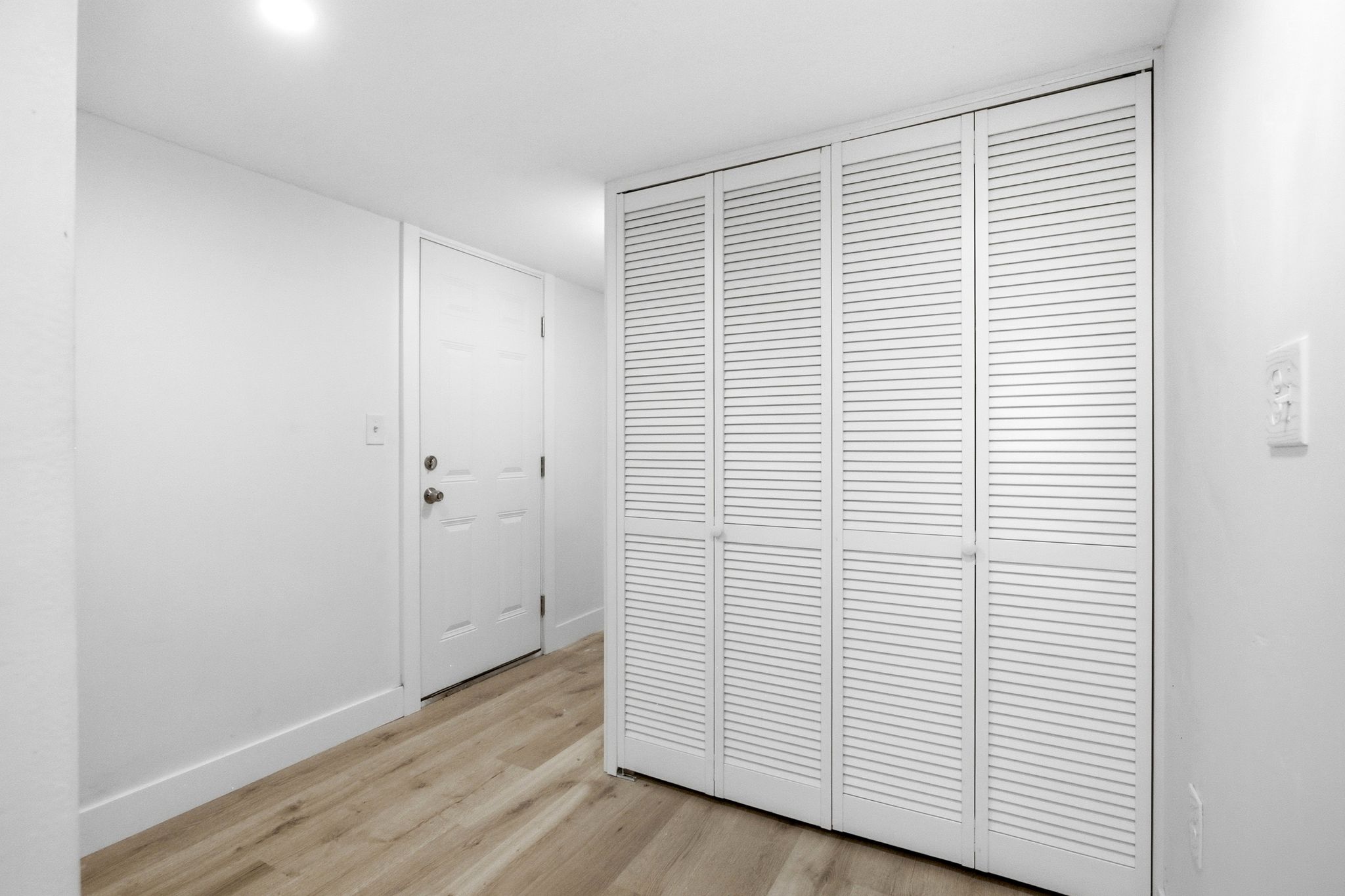 Wood-finish flooring provides a warm contrast to the white walls and trim