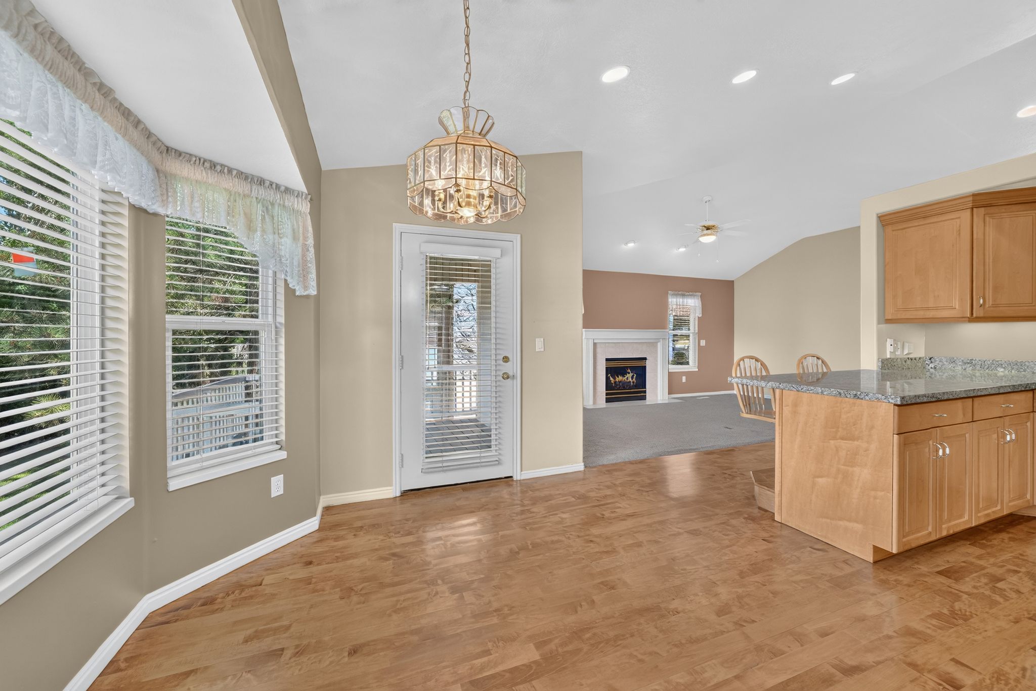 Kitchen with wood-finish flooring, light wood cabinetry, and granite countertops