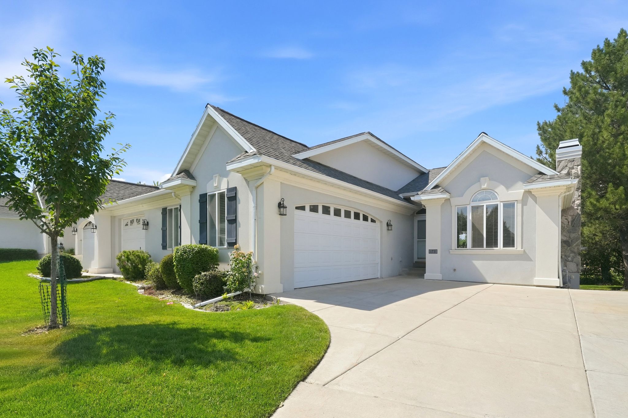 Stucco exterior with stone accenting, prominent gables, and multiple garage doors