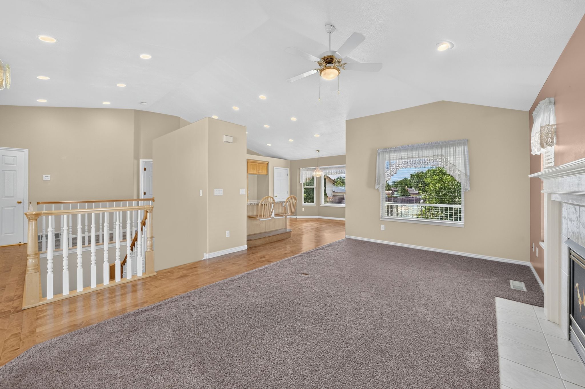 Vaulted ceilings with recessed lighting and a ceiling fan