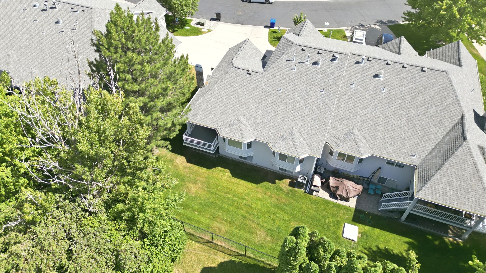 Rear exterior featuring a multi-level roofline with dormers, a covered patio, and an additional covered balcony