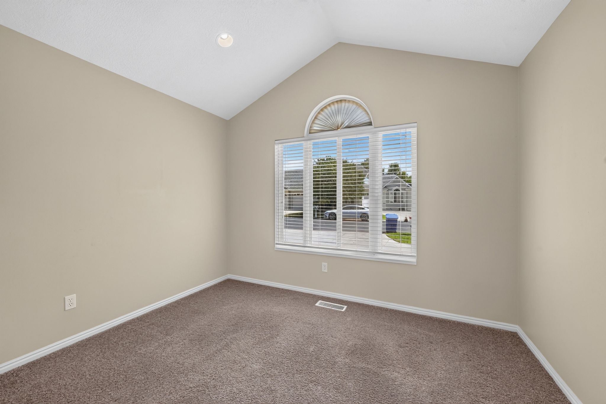 Room with vaulted ceiling, arched transom window, and horizontal blinds