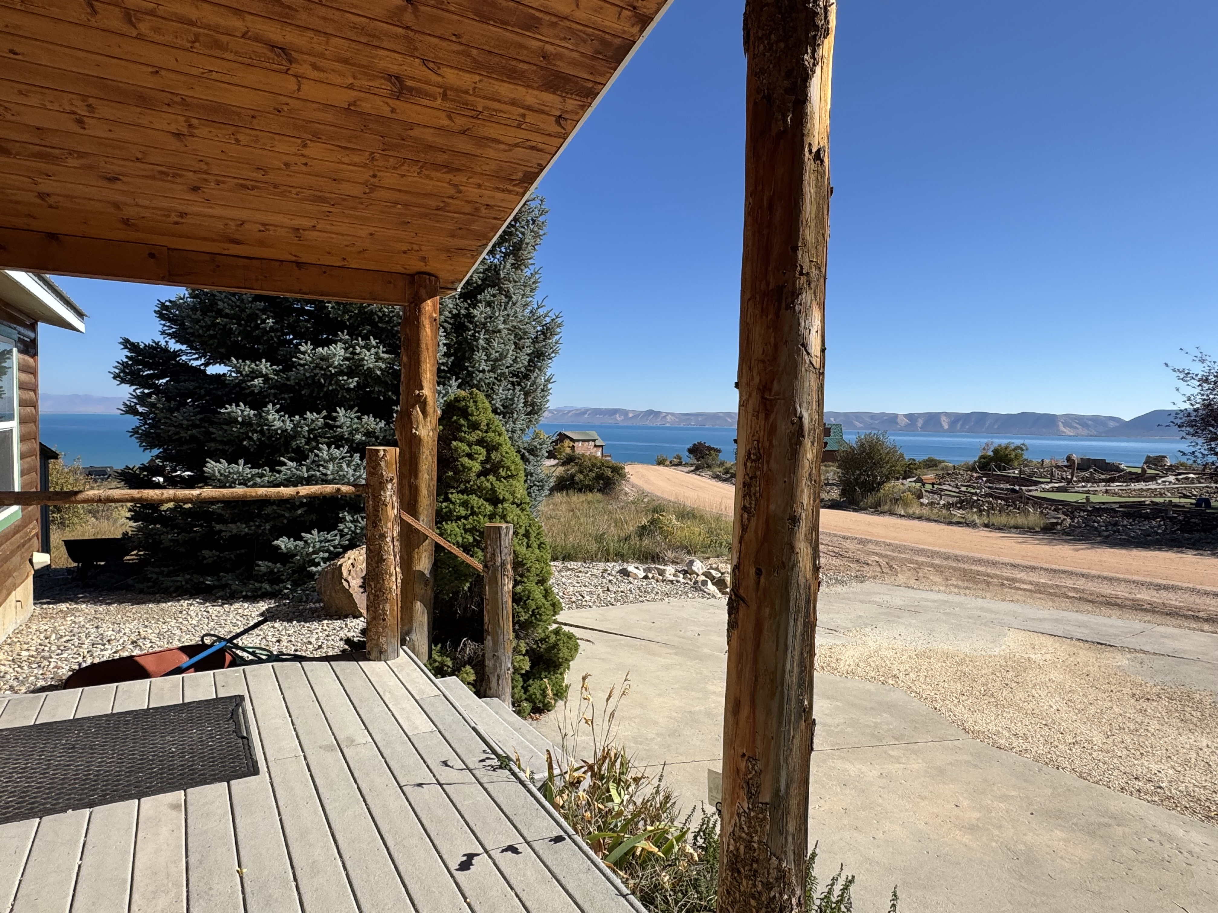 Covered porch featuring wood-finish ceiling and log support beams