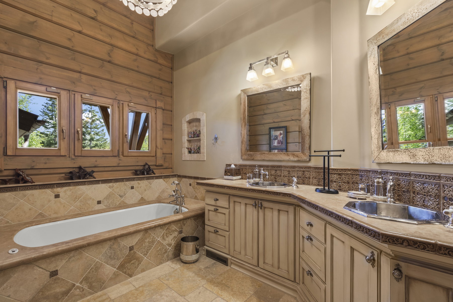 Bathroom featuring a built-in soaking tub with stone surround, wood-paneled walls, and a multi-window configuration