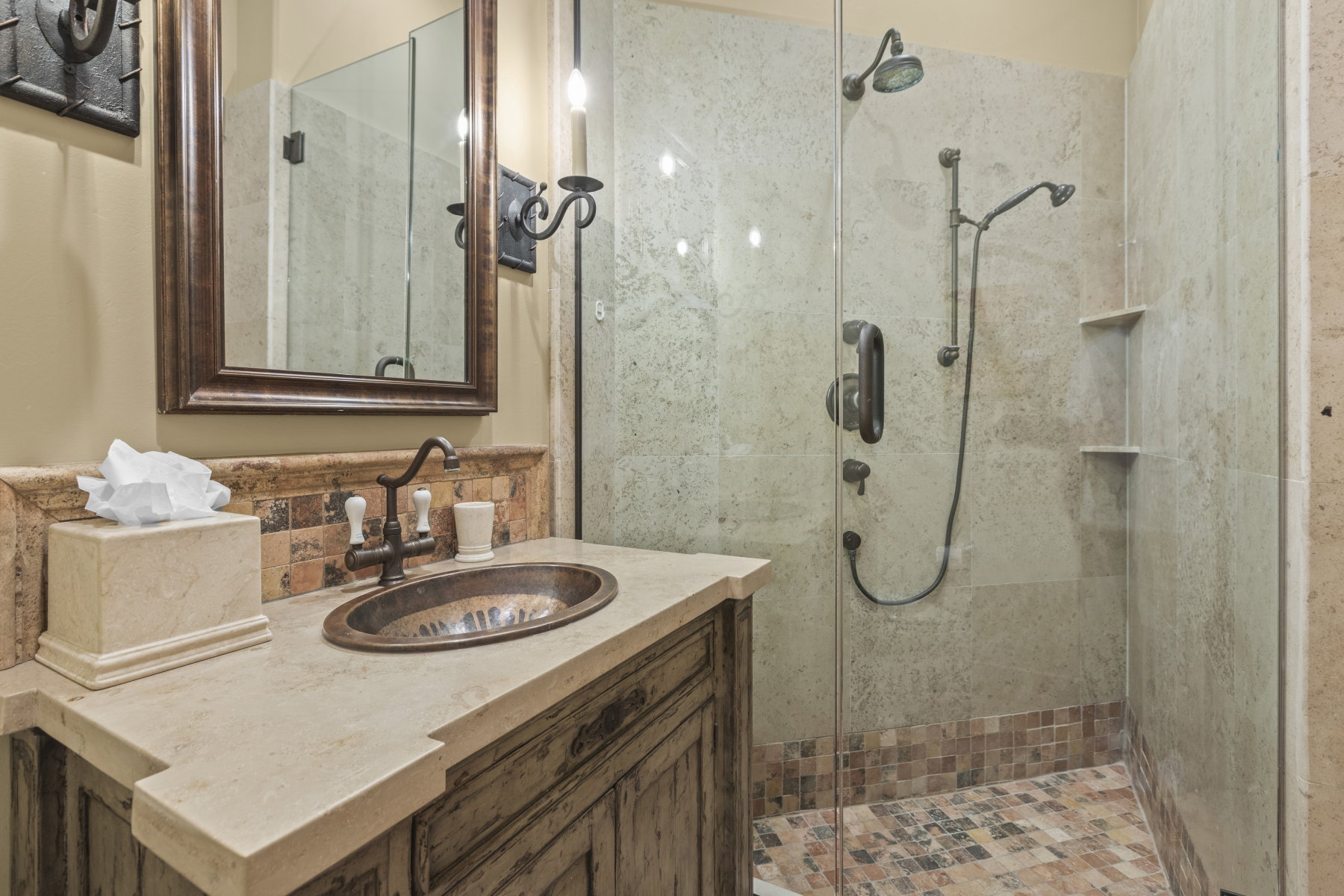 Bathroom featuring a rustic vanity with an oval vessel sink, a stone countertop, and a tiled backsplash