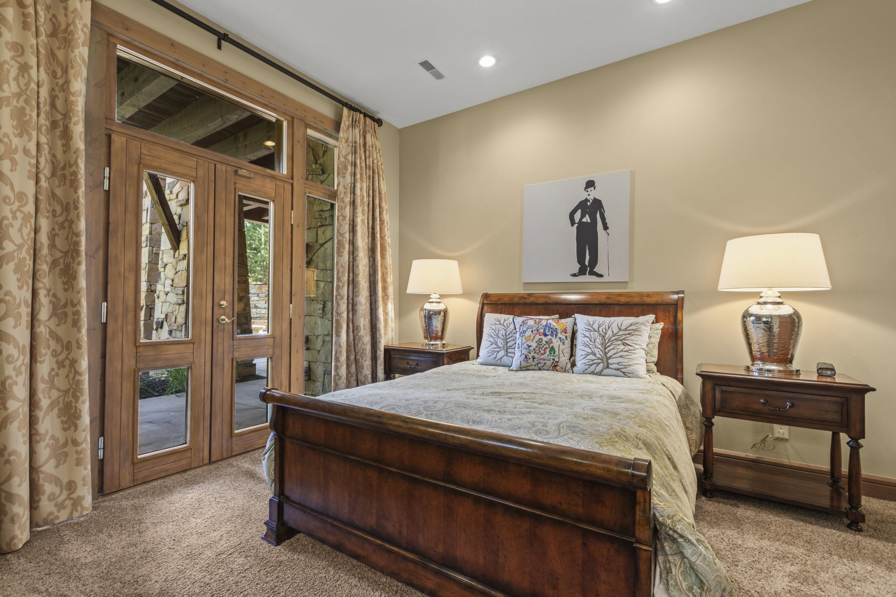 Glass-paneled double doors with transom and sidelight windows open to a stone-clad exterior