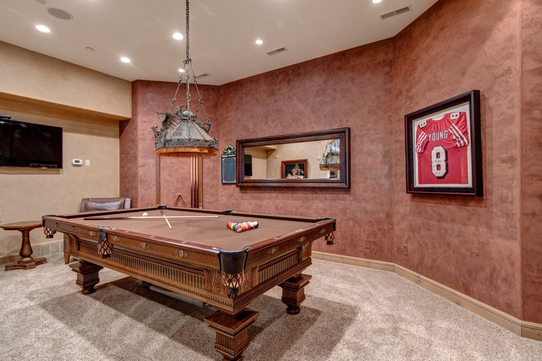 Recreation room featuring an ornate billiards table with a detailed wood frame, upholstered felt playing surface, and integrated ball pockets
