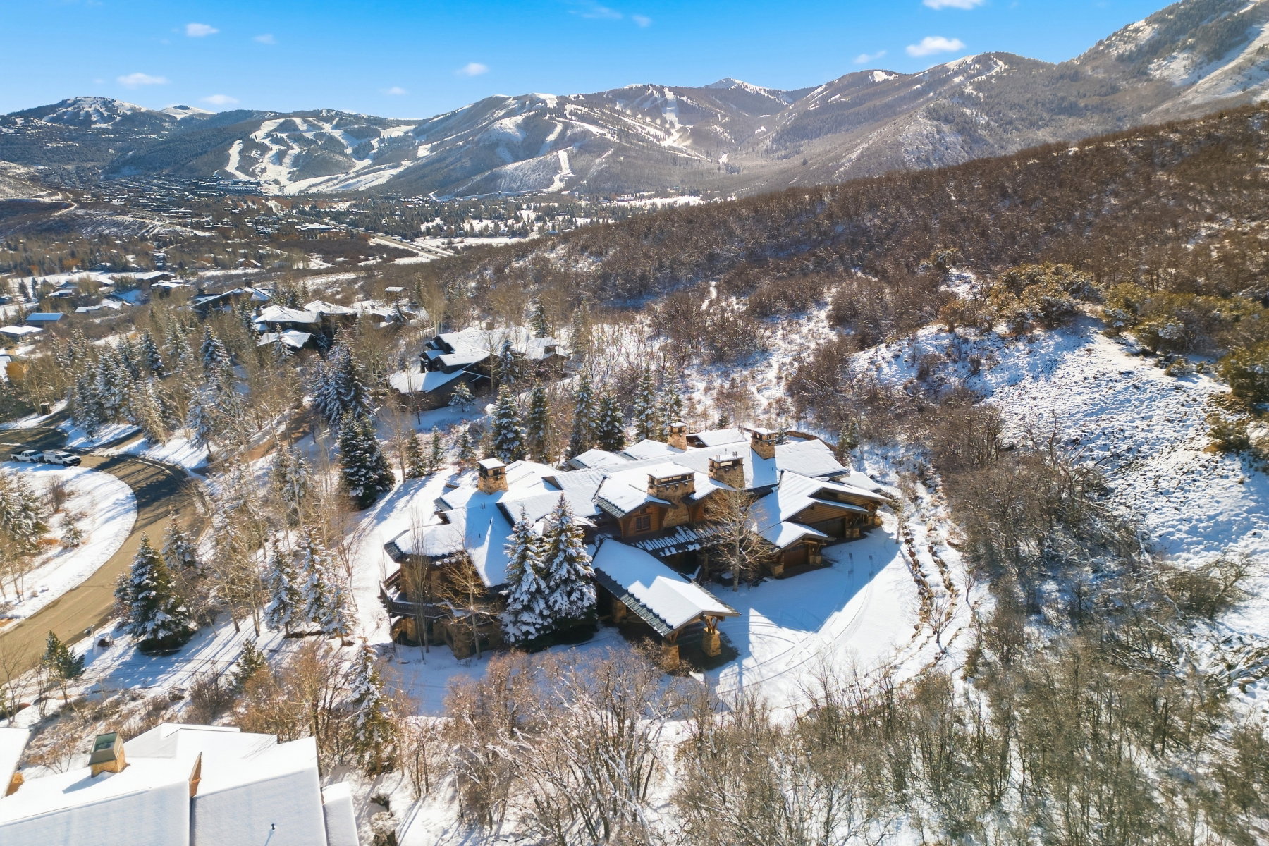 Expansive property featuring a multi-level structure with numerous chimneys, set against a mountainous backdrop