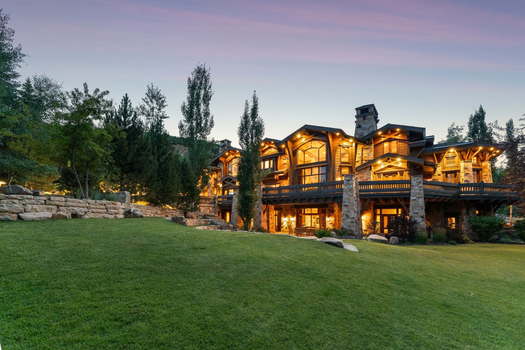 Expansive hillside property featuring a multi-story custom residence with stone and wood siding