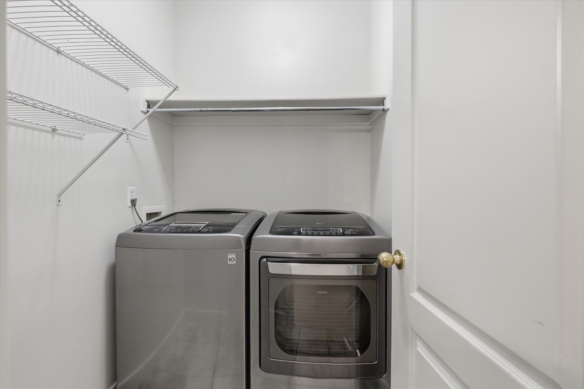 Dedicated laundry area featuring wire shelving, a clothing rod, and neutral wall tones