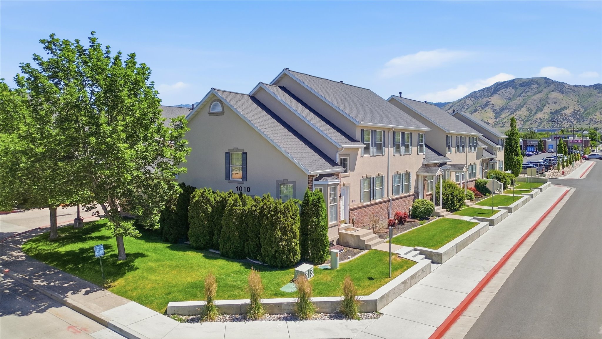 Row of townhomes featuring stucco and brick exteriors, pitched roofs, and shuttered windows