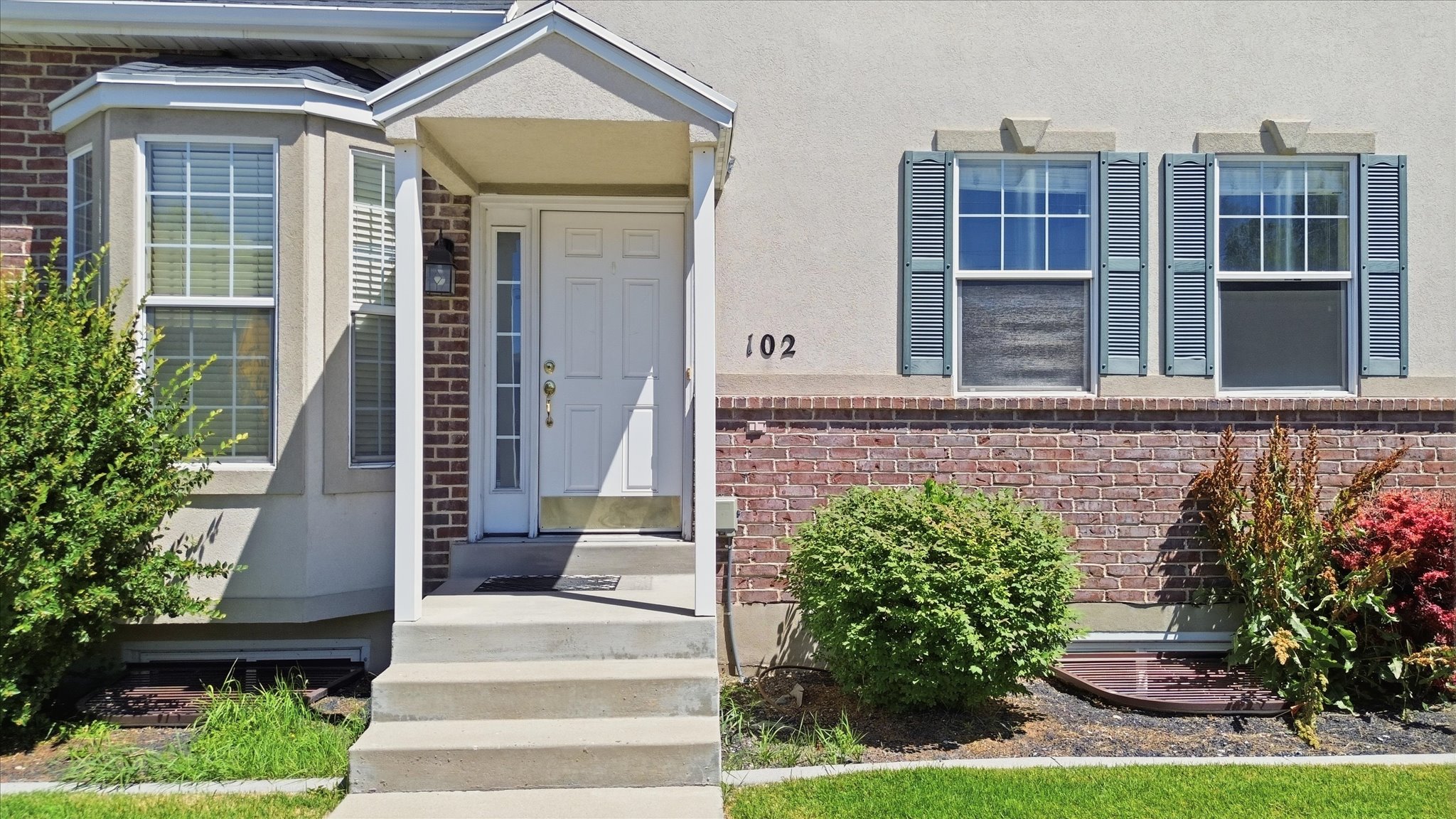 Brick and stucco exterior featuring a covered entry porch
