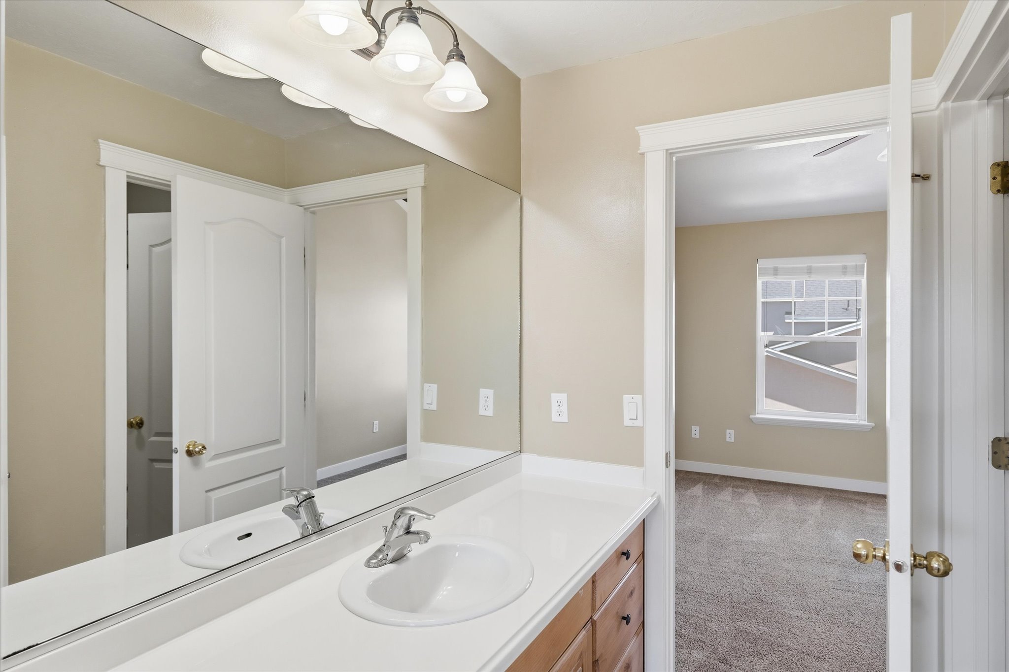 Bathroom vanity featuring a single-basin sink, chrome faucet, and a large wall-mounted mirror