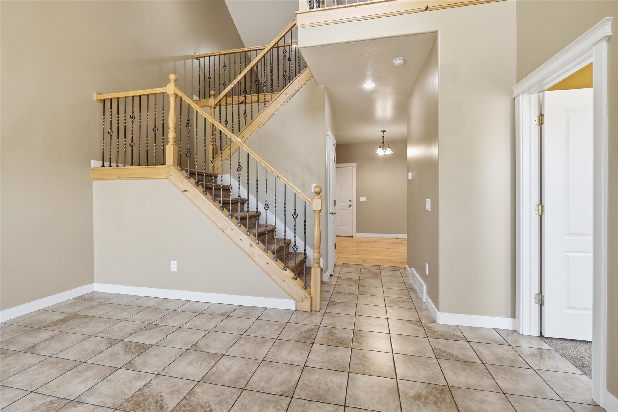 Grand entry with a multi-level staircase featuring wood handrails and decorative wrought iron balusters