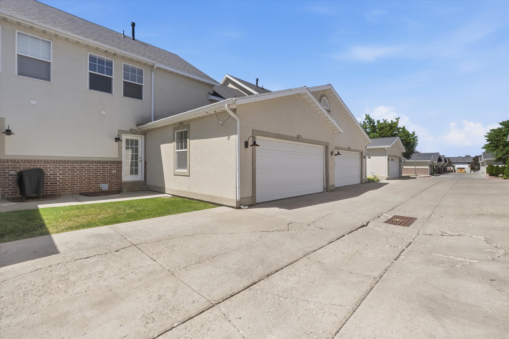 Attached garage featuring two white garage doors and exterior lighting fixtures