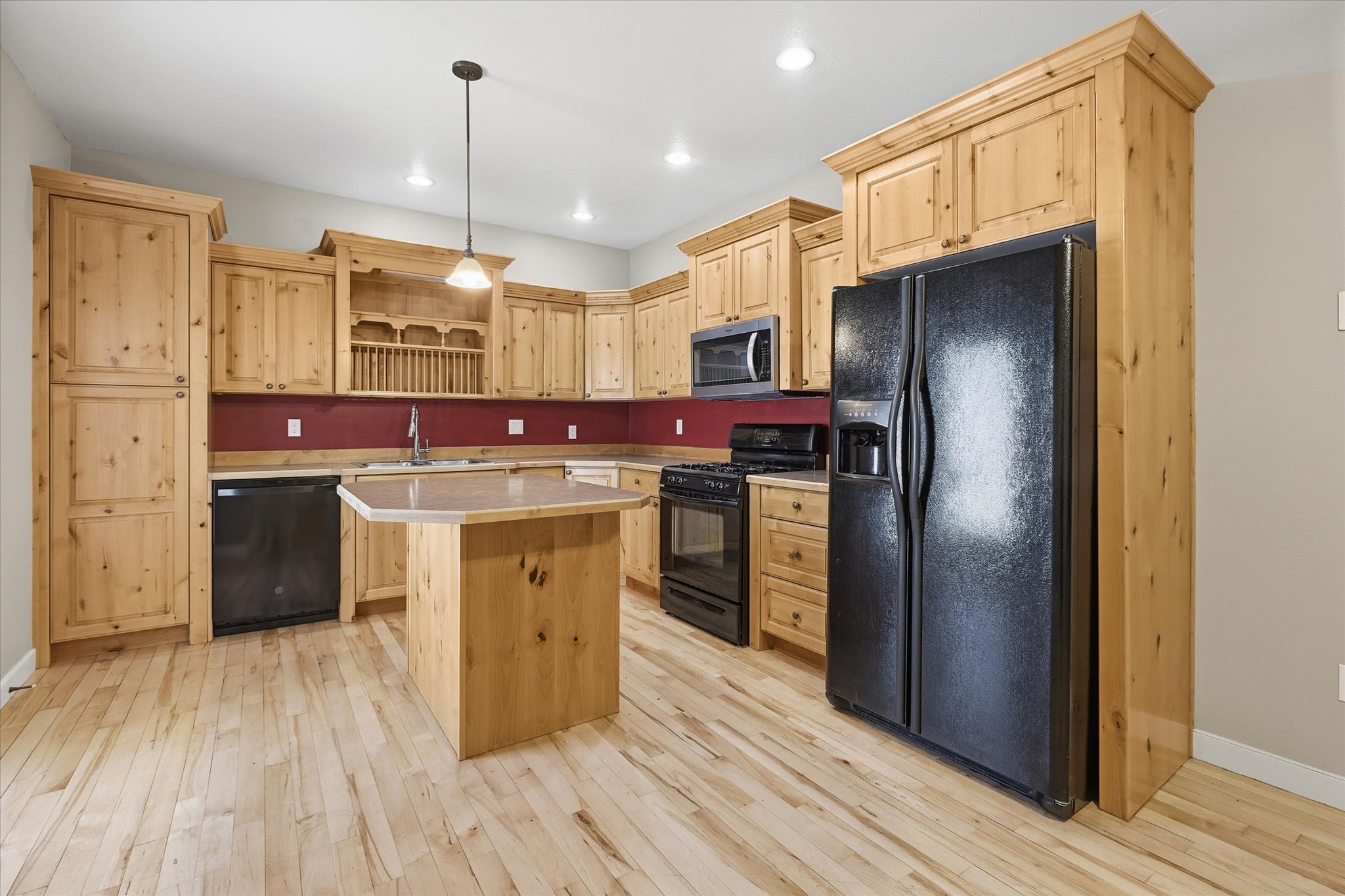 Kitchen featuring wood-finish cabinetry and flooring