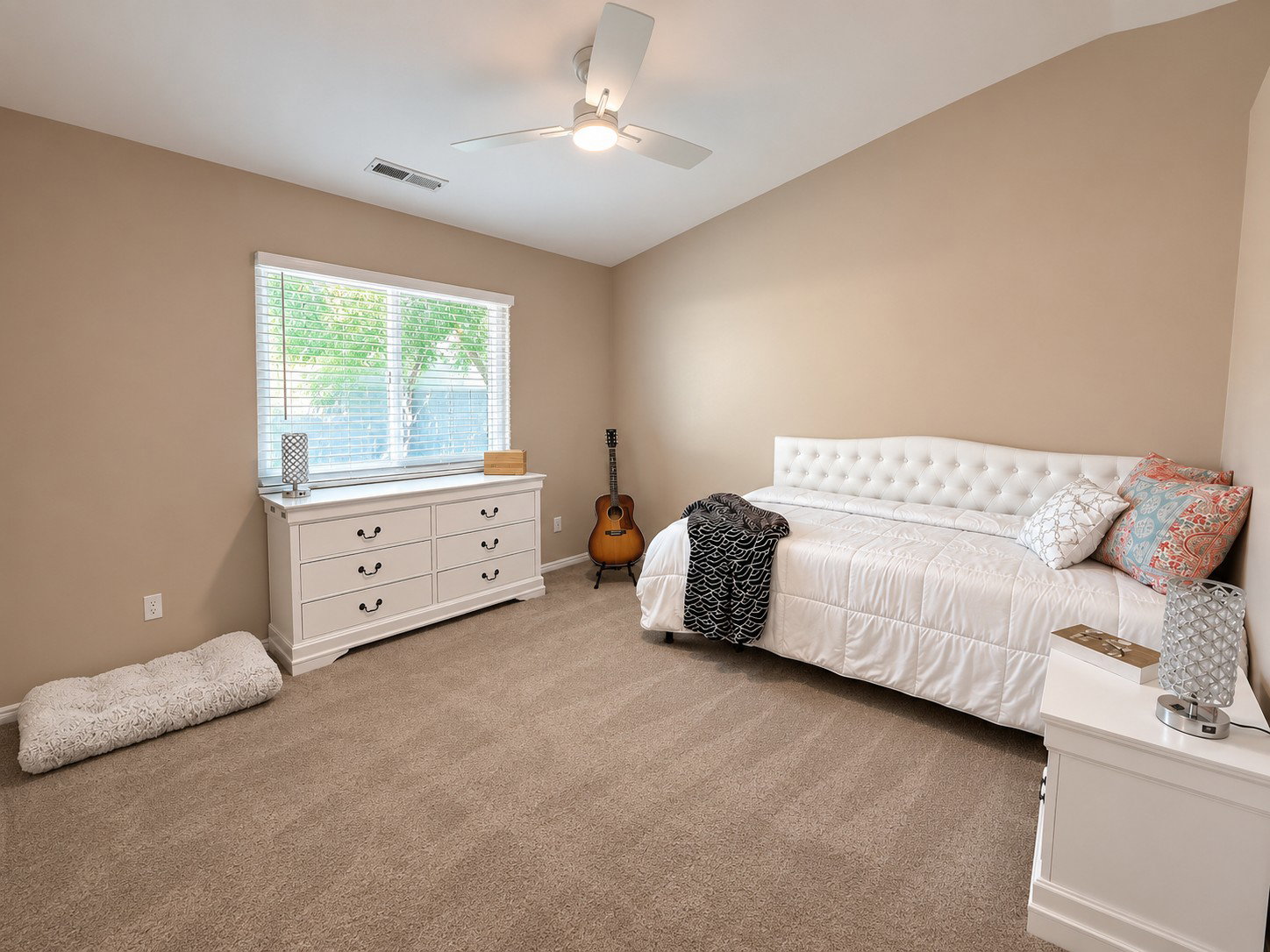 Carpeted room featuring a ceiling fan, a window with blinds, and neutral wall tones