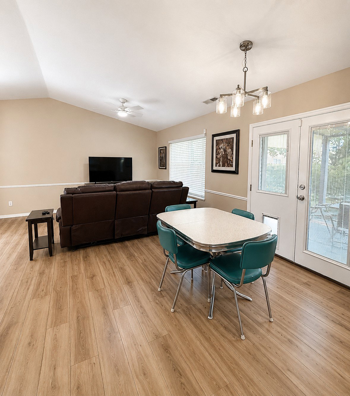 Open-concept living space featuring vaulted ceilings and light wood-finish flooring