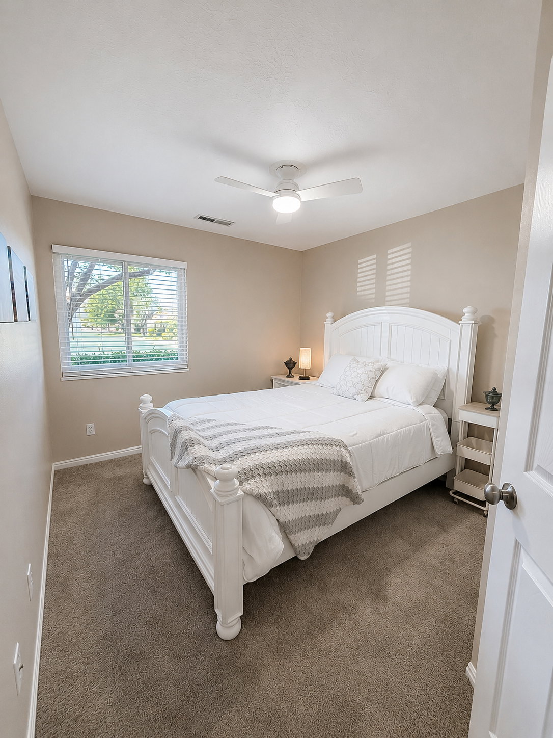 Bedroom featuring neutral wall tones, carpet flooring, a window with horizontal blinds, and a ceiling fan with integrated lighting