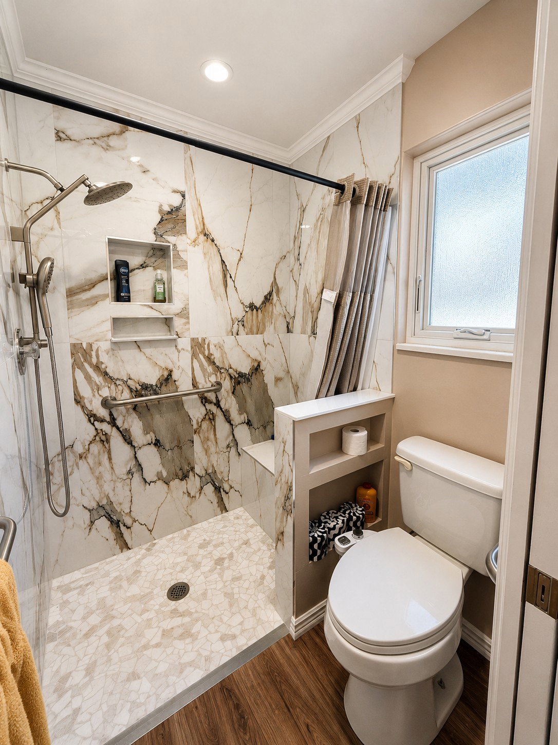 Walk-in shower featuring large format veined wall tiles, a built-in shower bench, and a dual shower head system