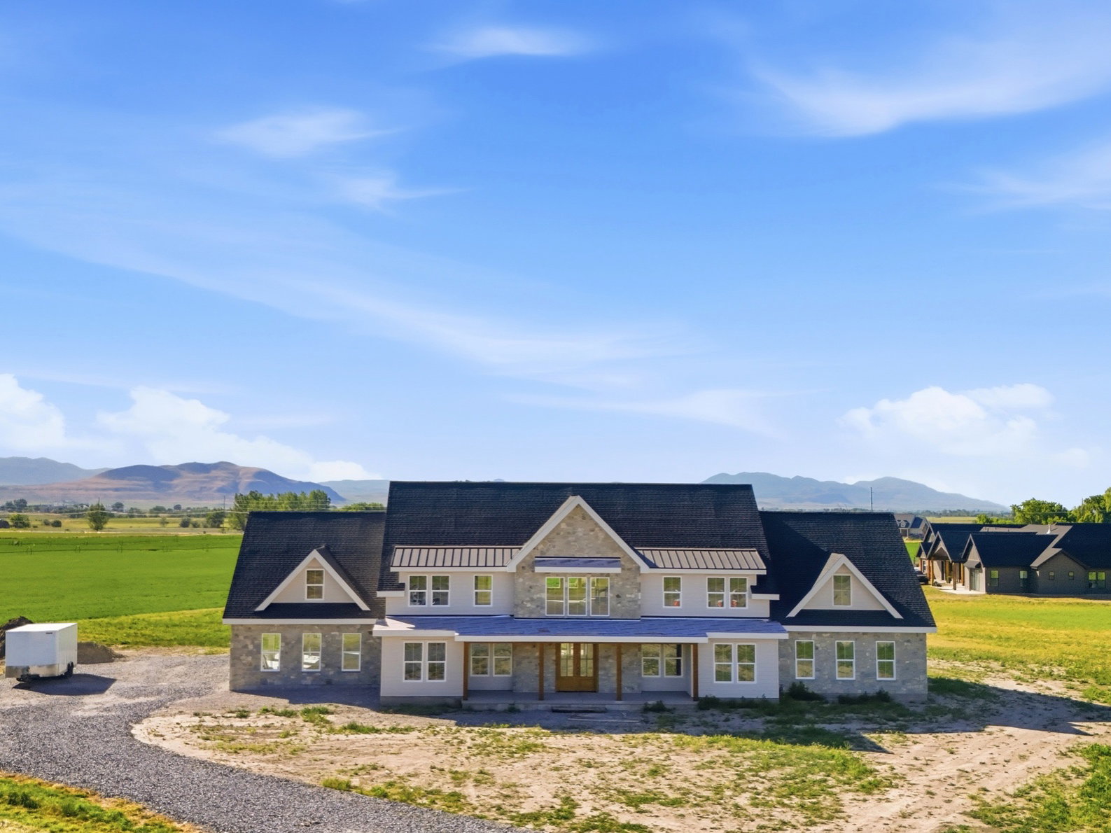 Expansive residential structure featuring stone and siding exterior with multiple gables