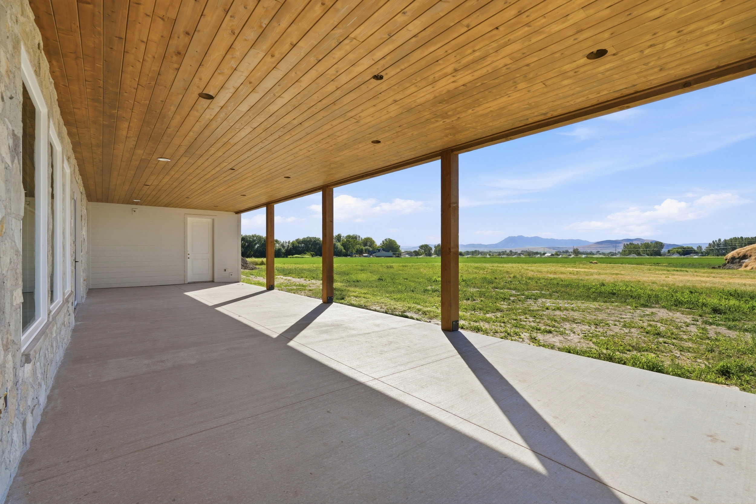 Covered outdoor patio with a wood-plank ceiling and recessed lighting