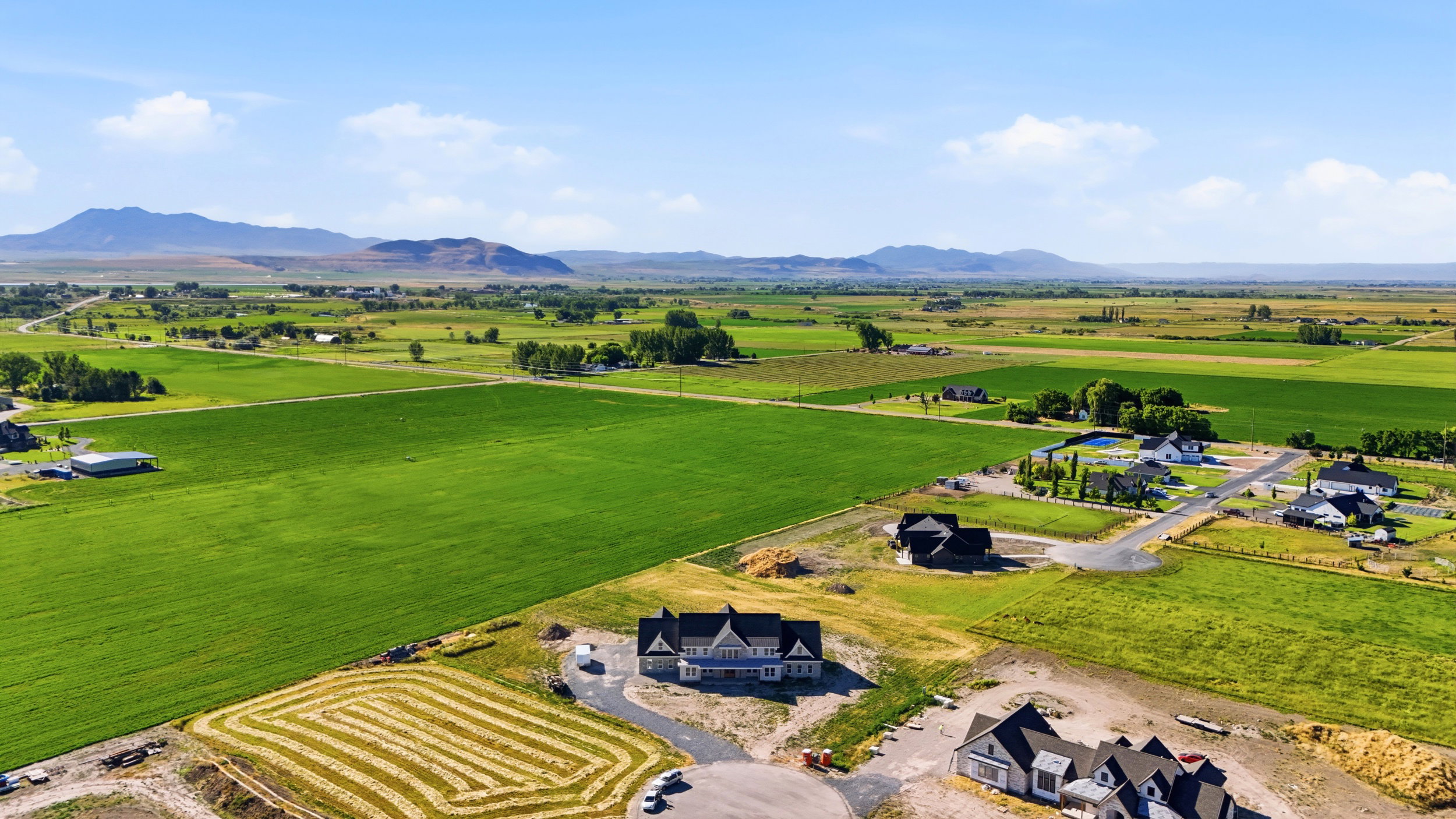 Expansive green fields surrounding newly constructed residential properties