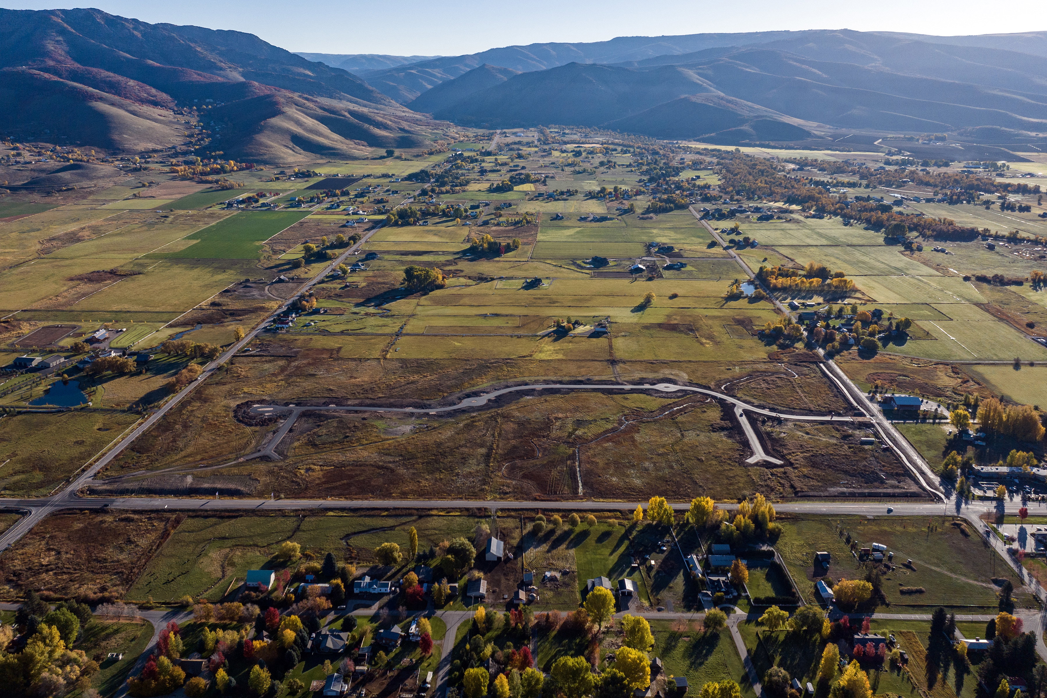 Expansive land parcels featuring varied topography, established roads, and distant mountain ranges