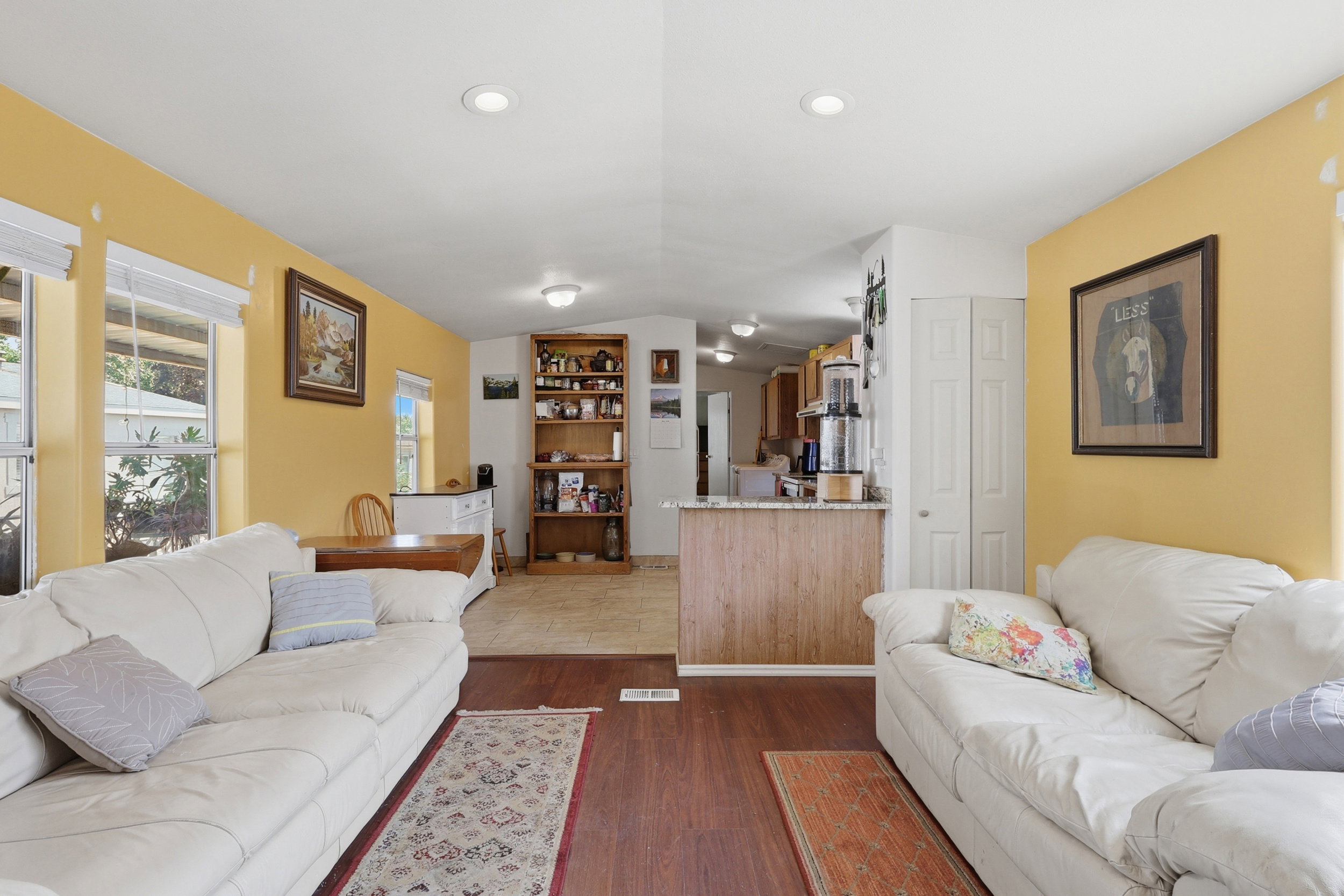 Living area featuring wood-finish flooring, recessed lighting, and multiple windows providing natural light