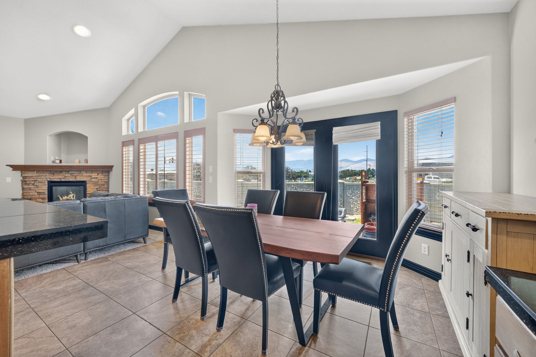 Open-concept living area featuring a vaulted ceiling and tile flooring