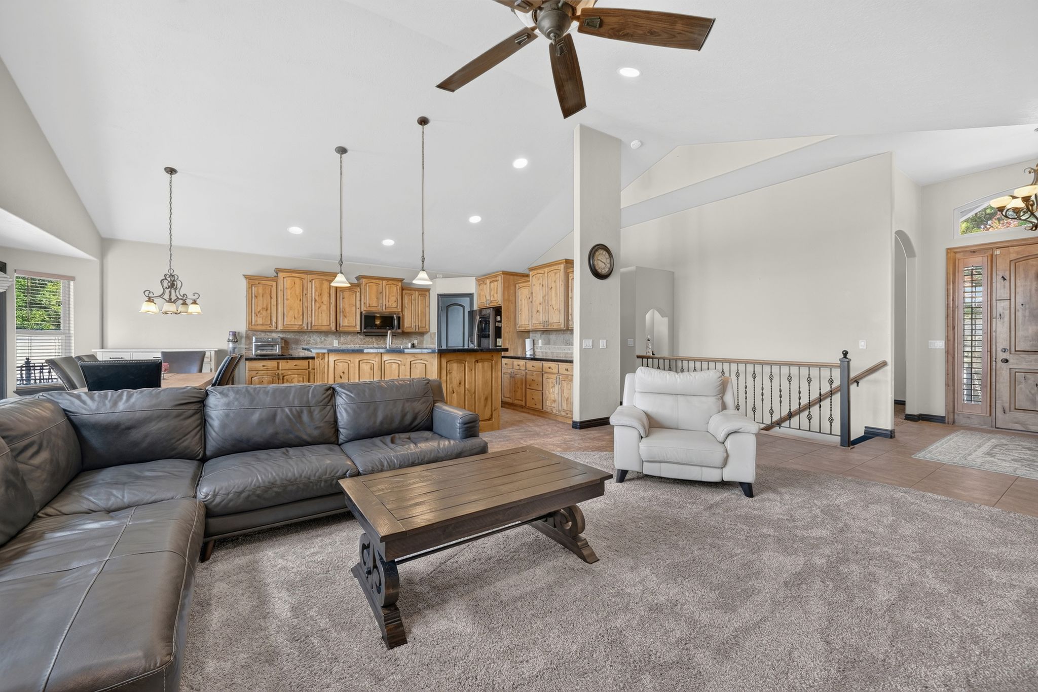 Vaulted ceilings enhance the main living area, featuring recessed lighting and a ceiling fan