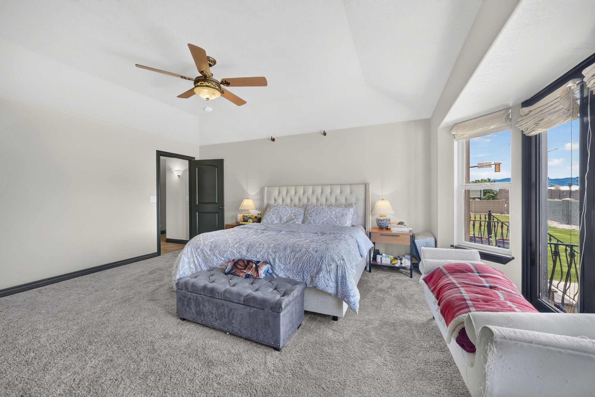 Carpeted room with a tray ceiling and a ceiling fan