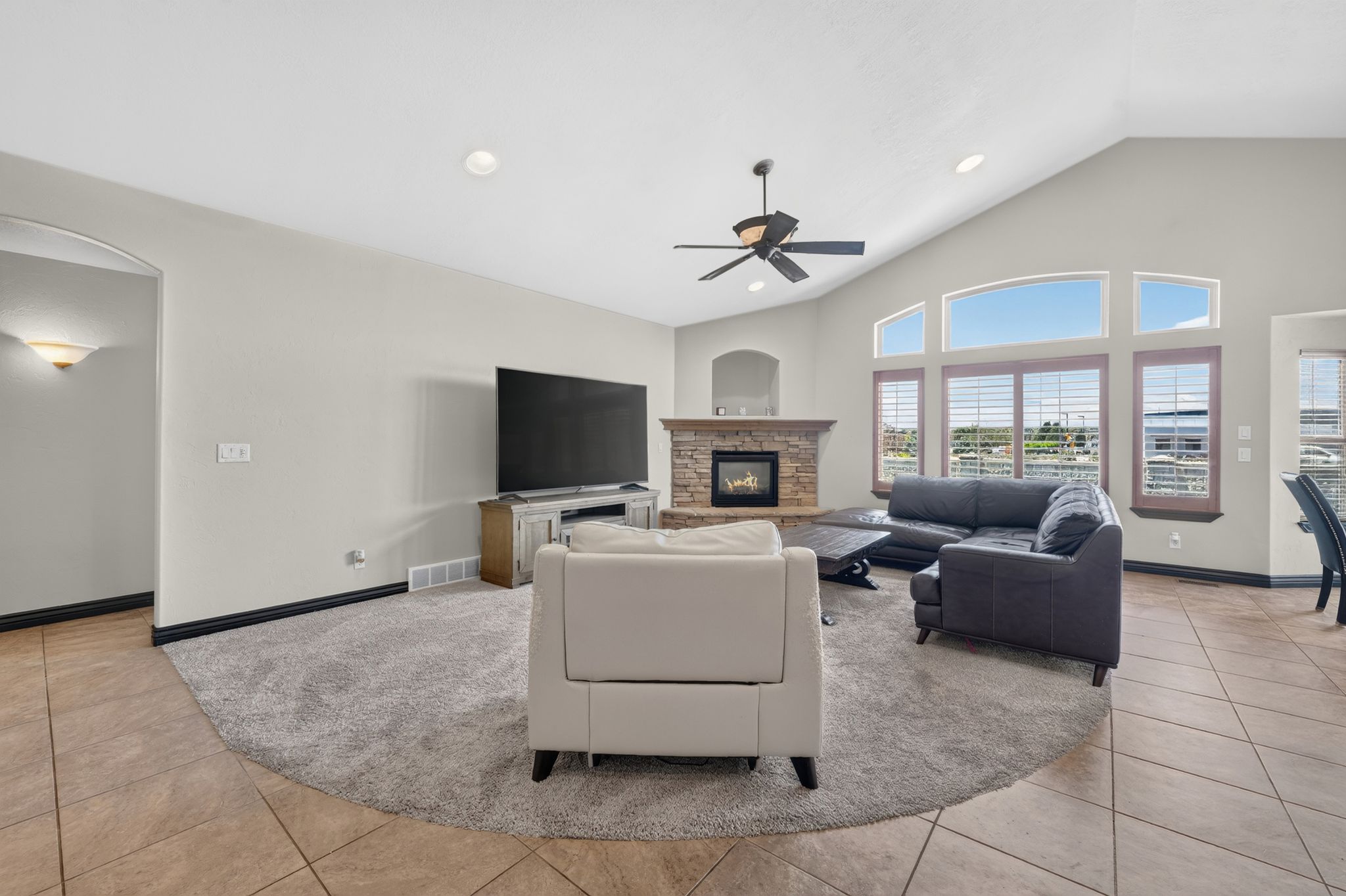 Living area with a vaulted ceiling, recessed lighting, and a ceiling fan