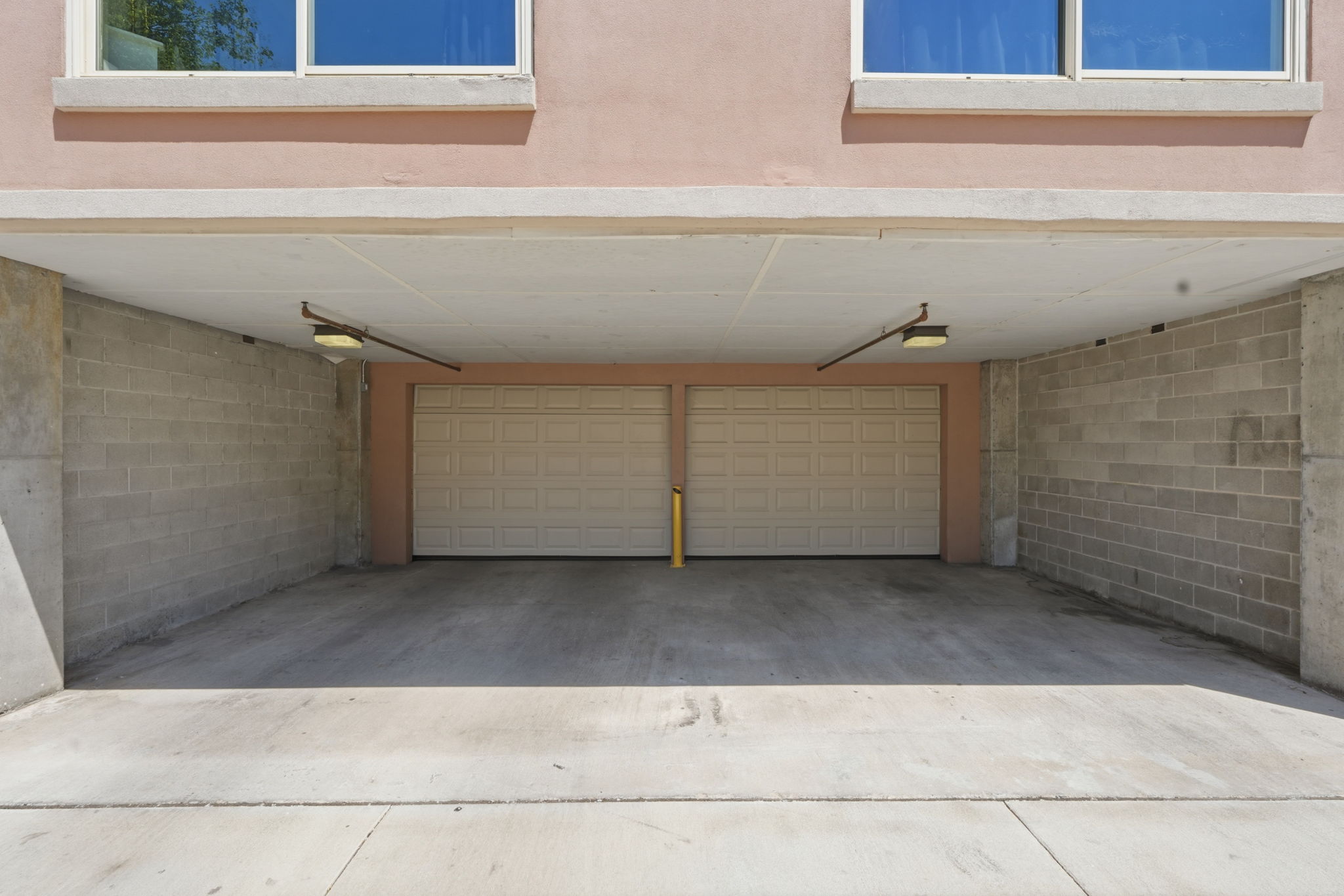 Secure covered parking area with two panel garage doors