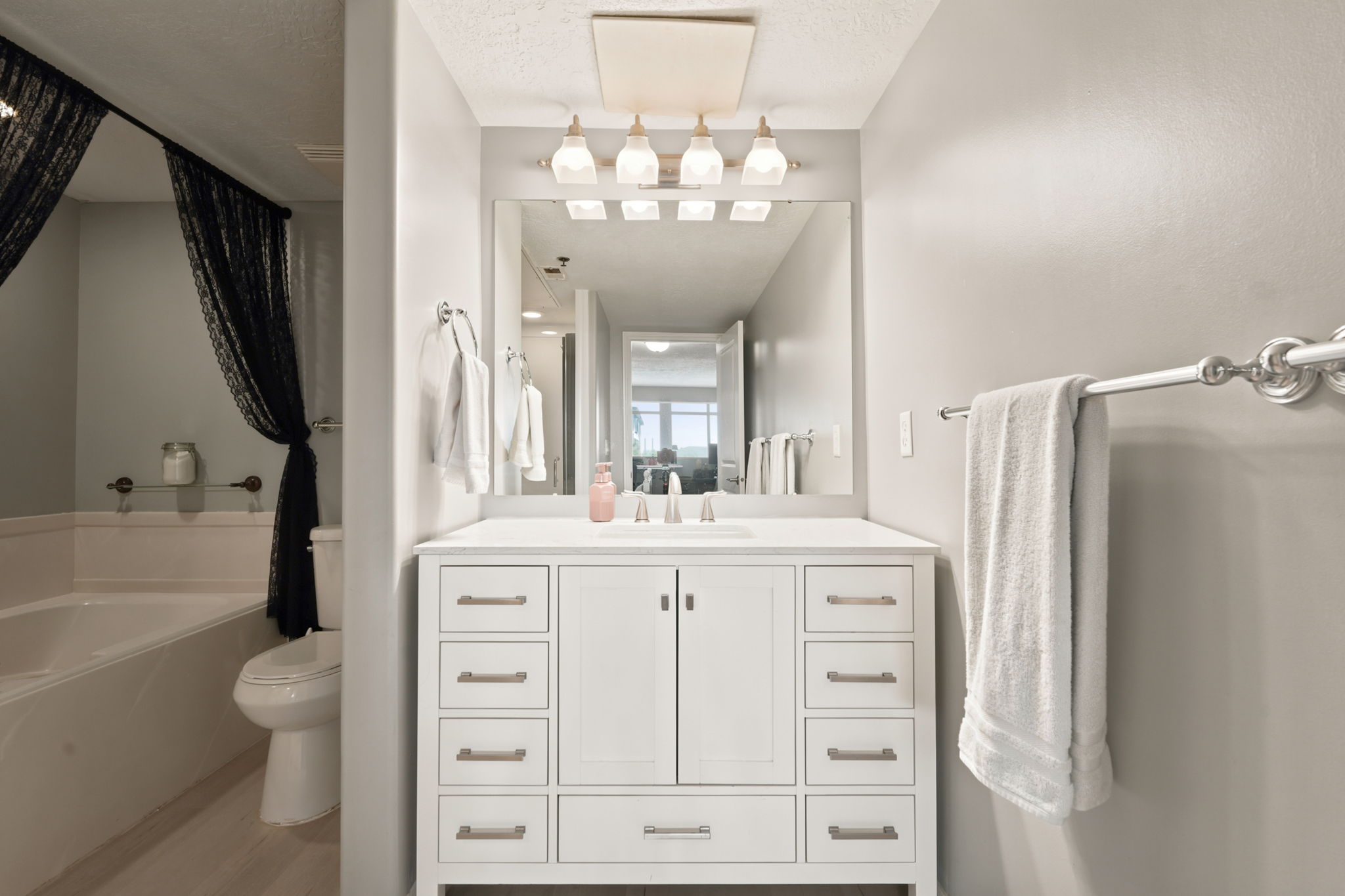 Modern bathroom vanity featuring a white countertop, undermount sink, and brushed nickel fixtures