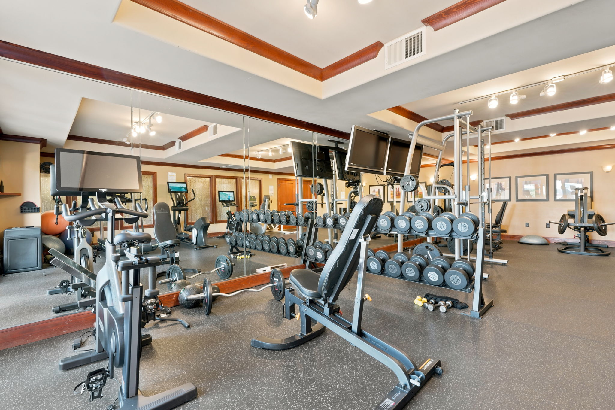 Fitness room with rubberized flooring, mirrored walls, recessed lighting, and crown molding