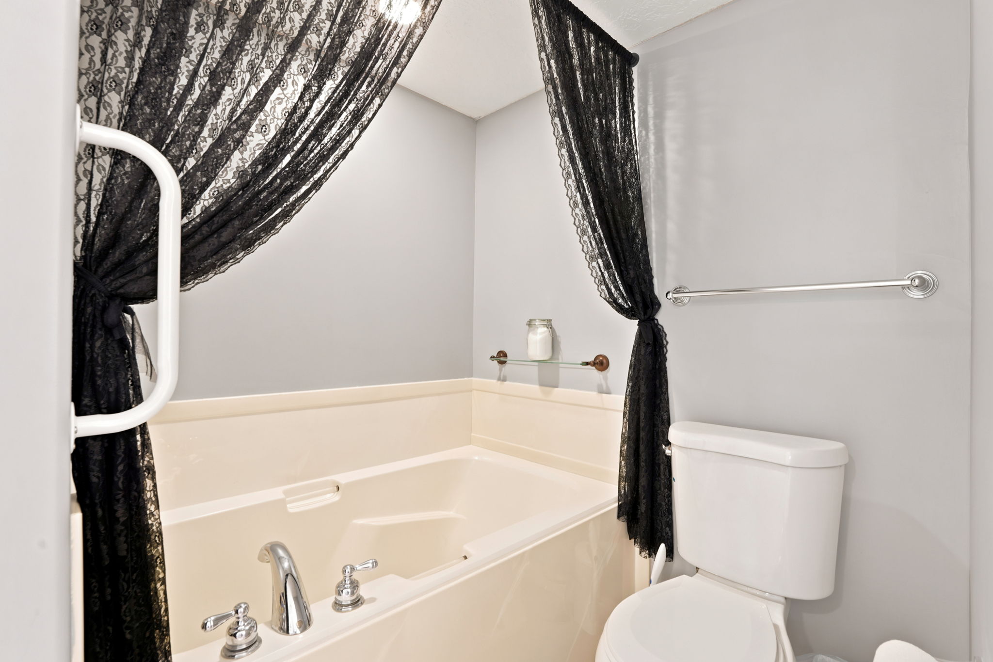 Soaking tub with chrome fixtures and light-toned surround