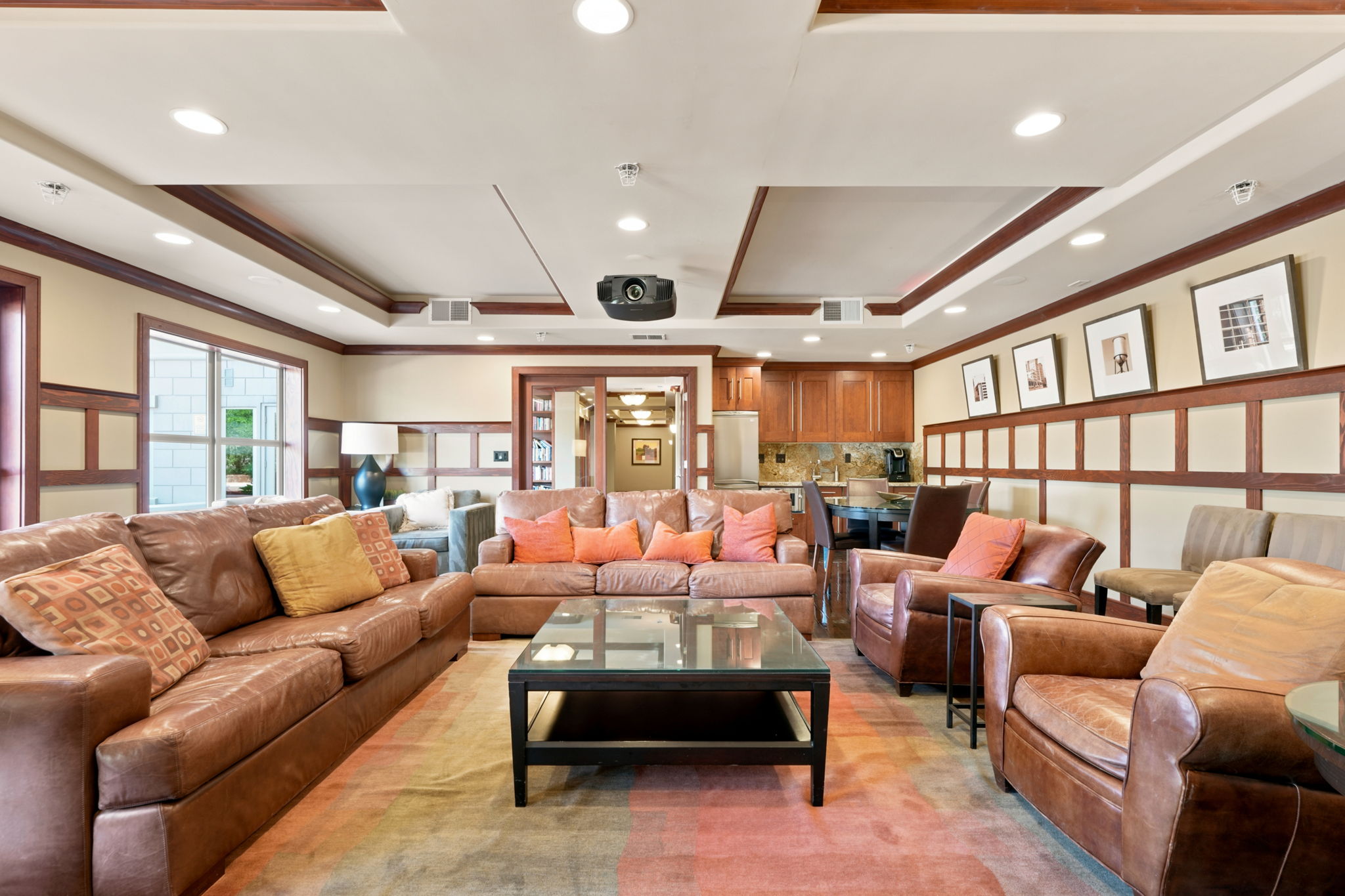 Spacious common area featuring recessed lighting, a ceiling-mounted projector, and extensive built-in cabinetry