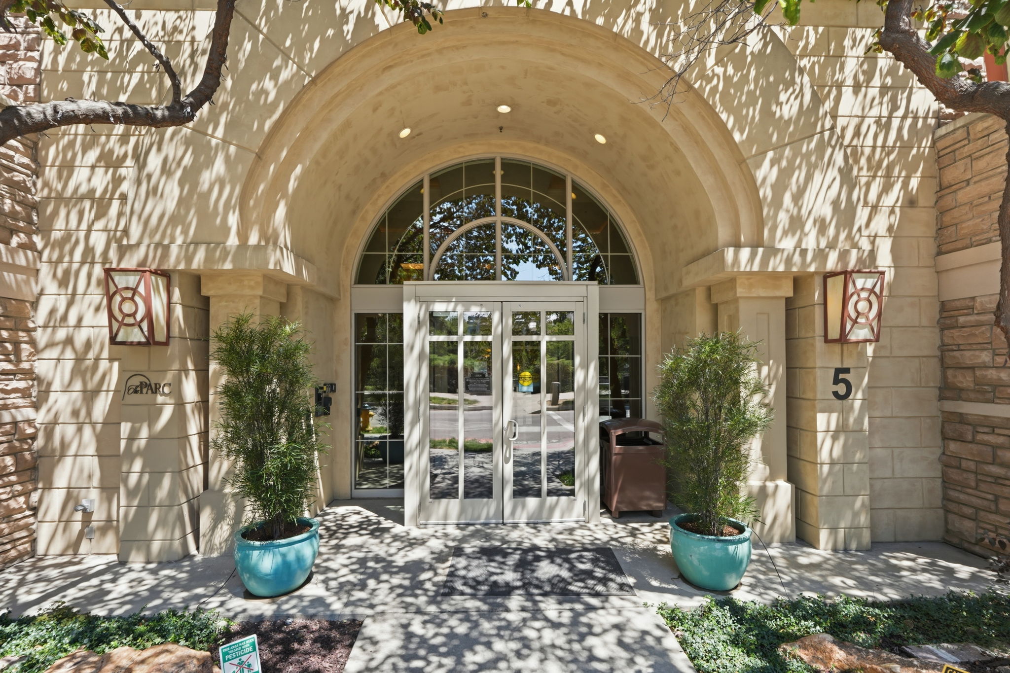 Arched entrance with a segmented glass transom and double glass doors